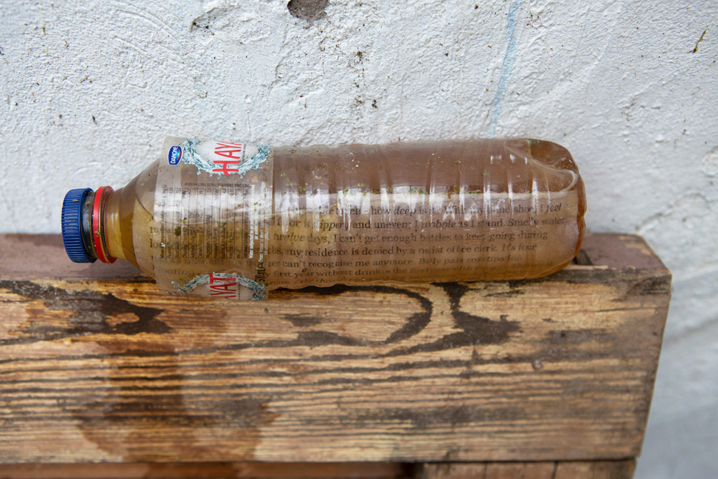 A 500ml water bottle of piss leaking down a wooden door